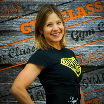 Mosolygó nő edzőteremben áll.