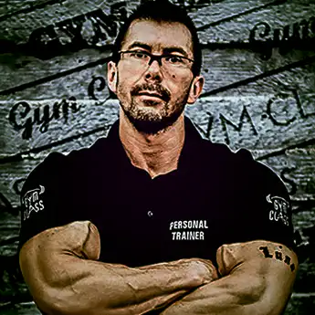 Személyi edző karba tett kézzel posztol.